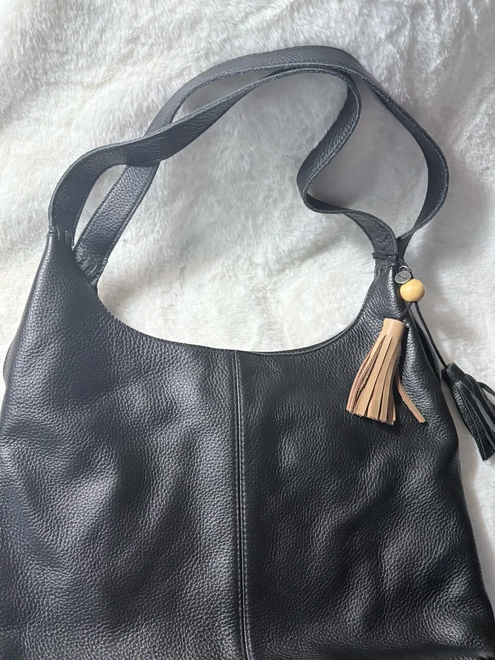 The Sak Black Leather Shoulder Bag with Tan Tassel Charm